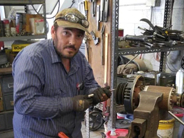 AEMS technician servicing a motor rotor clamped in a shop vise